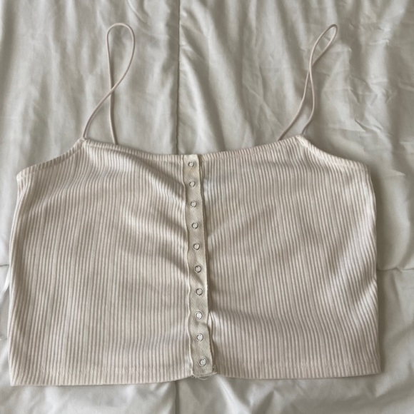 This is a medium sized white cropped tank top with a button down. - Picture 1 of 4